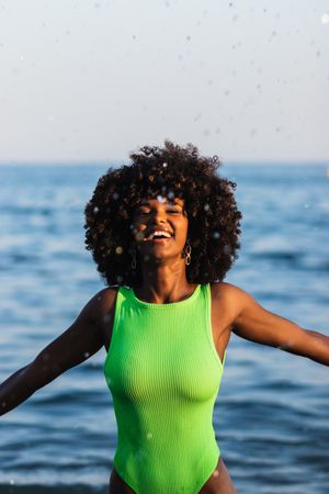 Black woman splashing water in sea