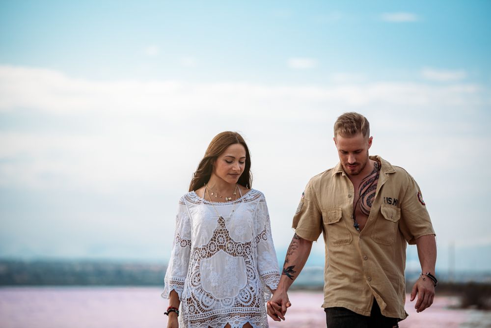 adorable couple walking on an amazing beach with pink water