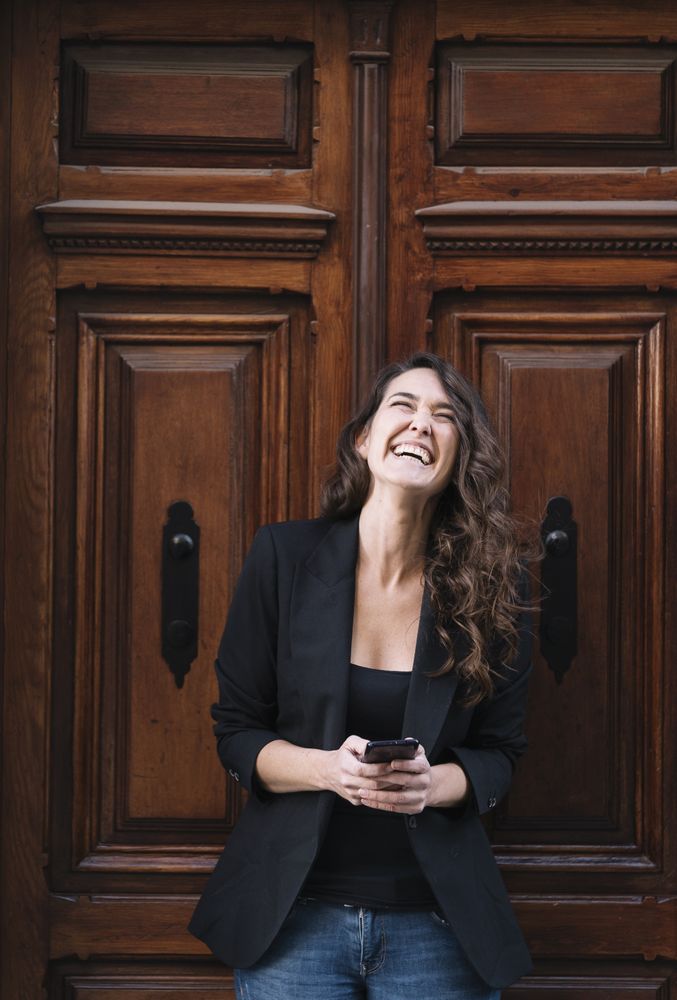 Young female using mobile phone on wooden door