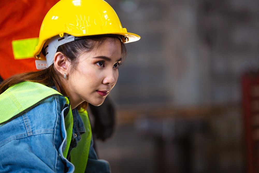 Female factory worker or engineer looking forward with blank space