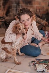 Woman with dog painting at home