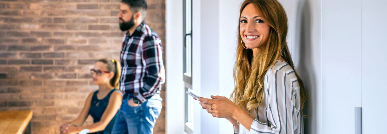 Happy businesswoman looking at camera in office