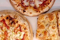 Overhead portrait of several pizzas