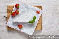 Above view of slice of cheese with strawberries 0gjveb