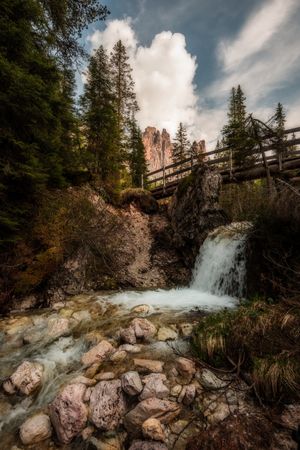 Small waterfall on rocky gorge under bridge