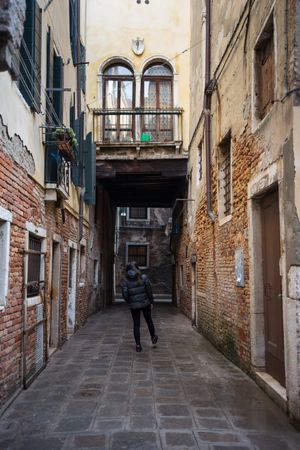 Anonymous woman strolling on rocked alley