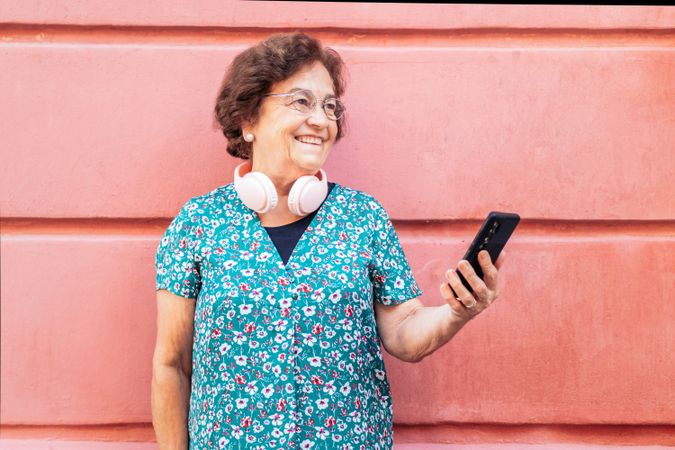 Smiling older woman using smartphone outdoors
