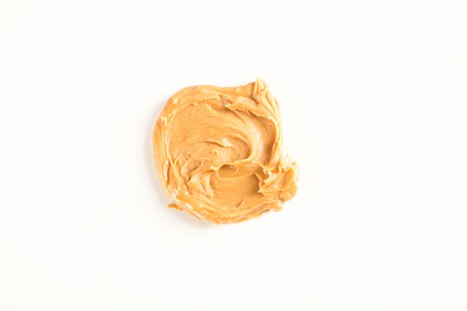 Creamy peanut butter isolated on bright background, top view. A traditional product of American cuisine