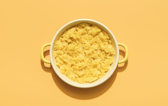 Scrambled eggs above view minimalist on an orange background