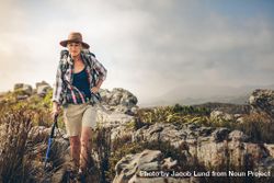 Mature woman wearing hiking gear walking on a rocky hill 4mRzWb