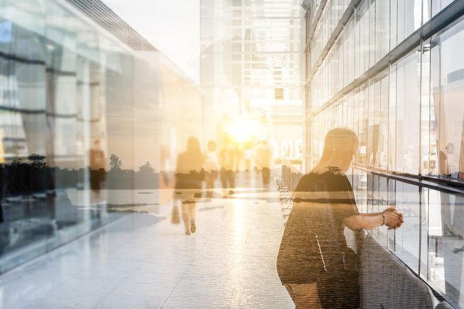 Art concept : double exposure of alone woman in the lobby in the rush hour of a modern business center think about the peaceful of nature