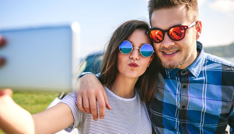 Young couple doing a selfie on the car