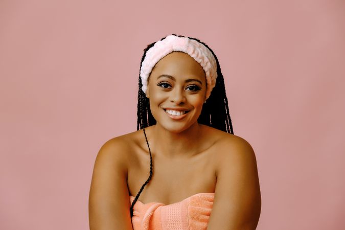 Smiling female in towel with her hair kept back in spa headband