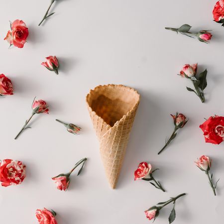 Ice cream cone with colorful flowers pattern on light background