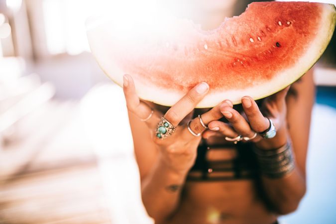 Woman holding a watermelon slice on a sunny day