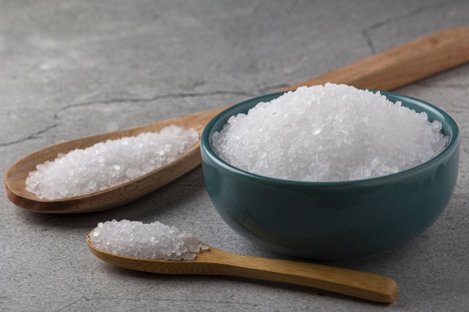 Bowl with coarse salt on the table.
