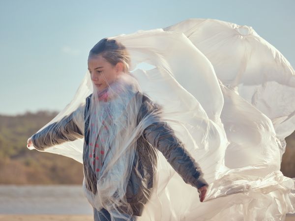 Sad girl caught in large film in nature