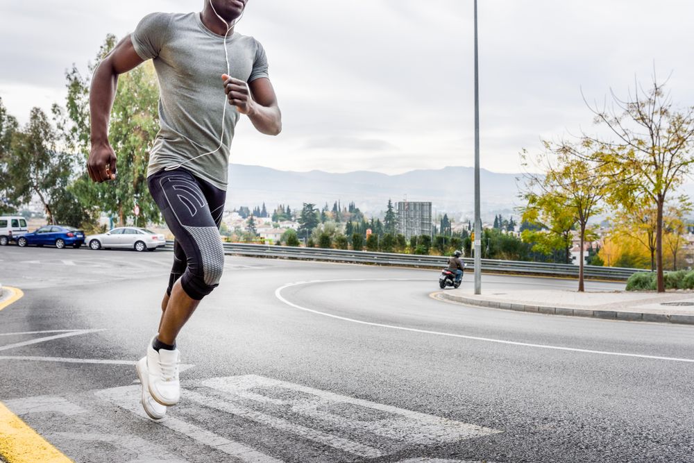 Body of male sprinting on city street