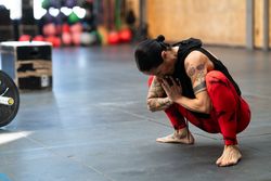 Woman doing squat stretches in gym