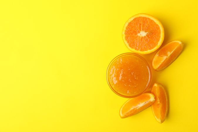 Delicious orange jam on yellow background, top view