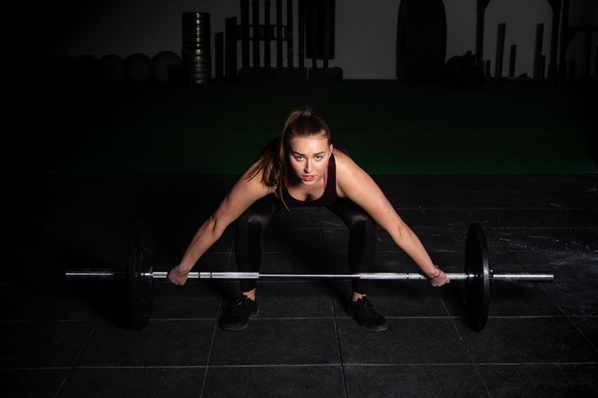 Woman lifting barbell in gym