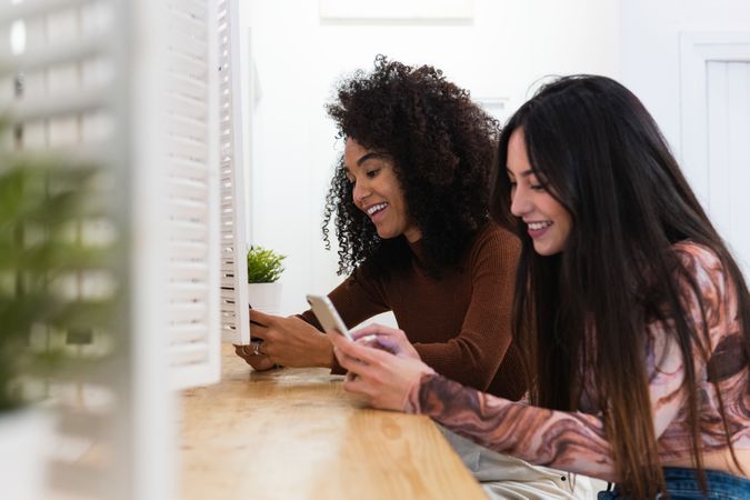 Happy multiracial women chilling together in bar