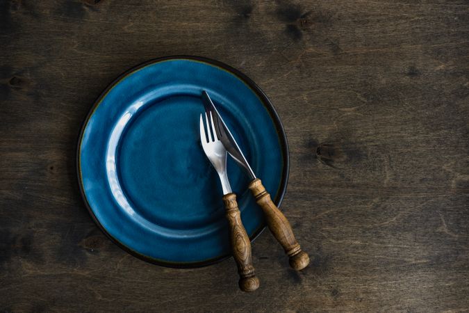 Rustic table setting with navy plate and cutlery and space for text