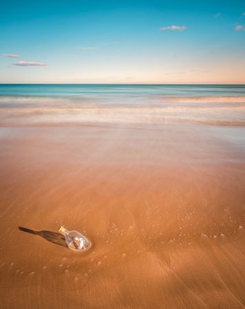 Bottle in sand near sea