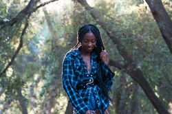 Portrait of Black woman with box braids standing in the woods