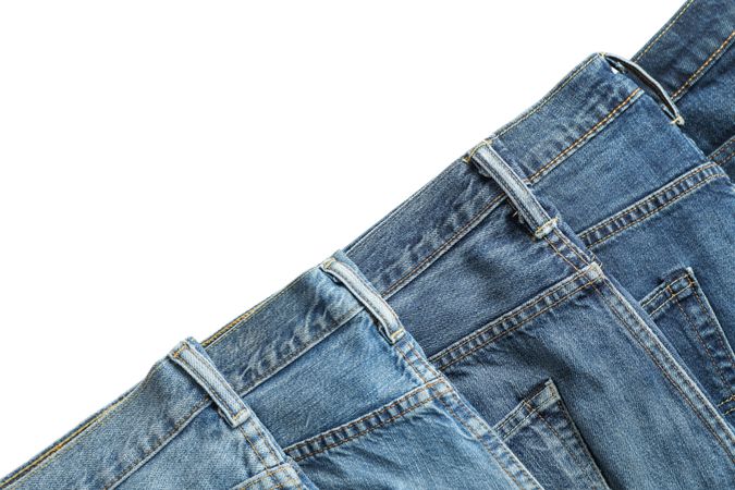 Jeans of different colors isolated on light background, space for text