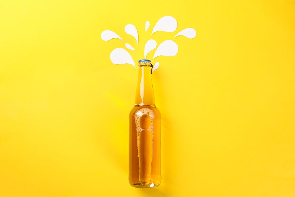 Bottle of beer on yellow background, space for text