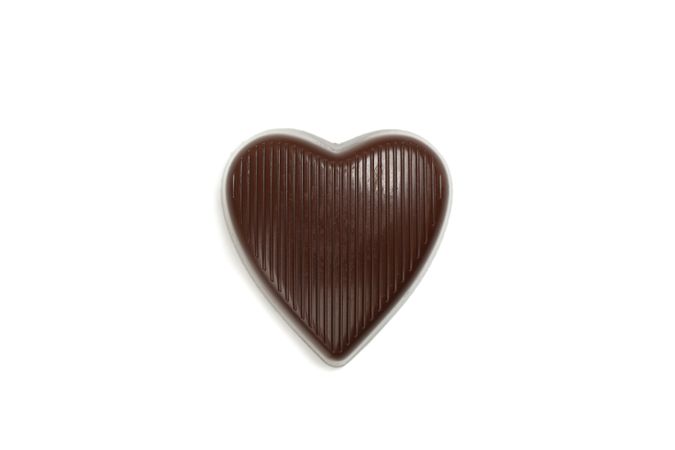 Tasty chocolate candy in the heart form isolated on studio background