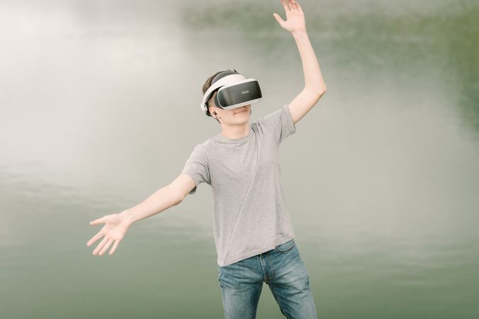 Young teenager with virtual reality glasses outdoors