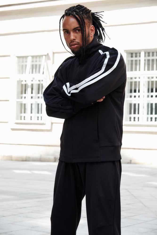 Black male standing with arms crossed