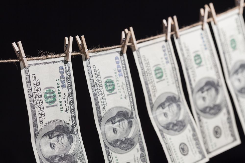 Hundred Dollar Bills Hanging From Clothesline on Dark Background