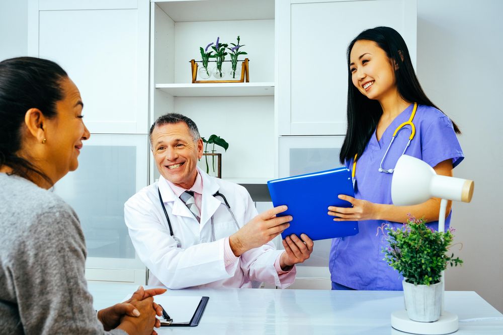 Smiling nurse handing doctor patient’s file in office