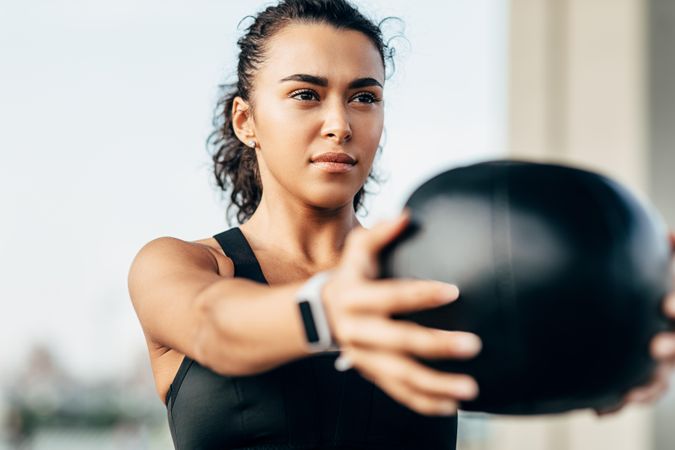 Woman working out her shoulders with medicine bar