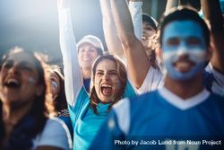 Argentinian woman with a group of cheering soccer fans in stadium 0L1Ly5