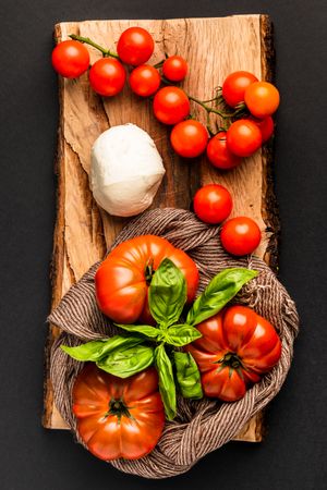 Tomatoes, mozzarella and napkin on wooden board
