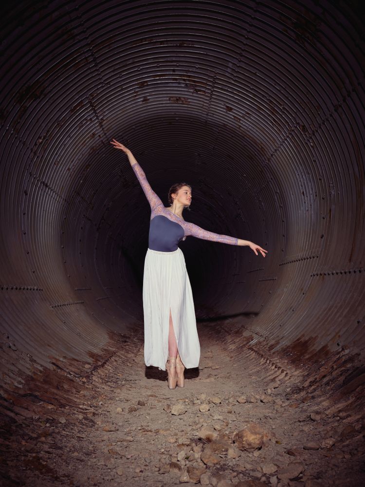 Graceful woman dancing ballet in shabby tunnel