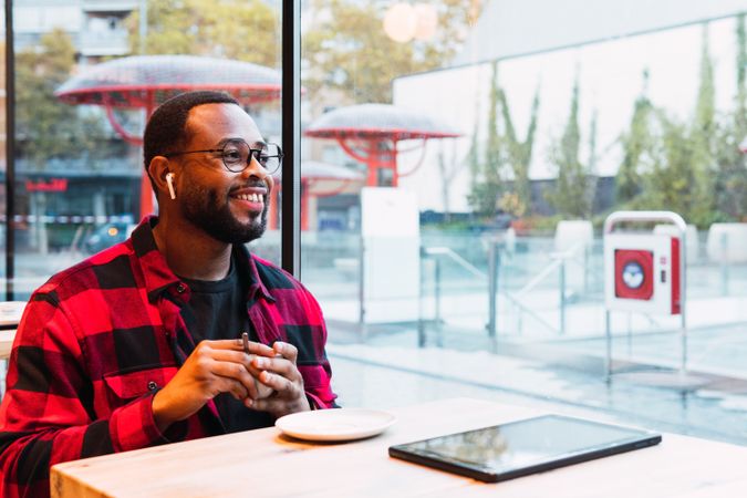 Smiling Black man with cup of coffee in cafe