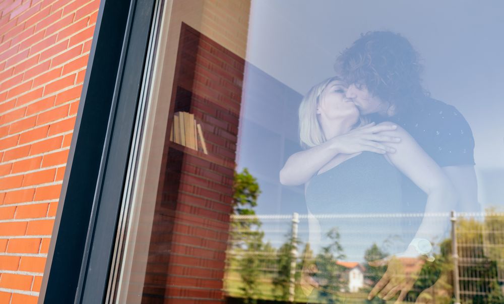 Couple kissing behind the window