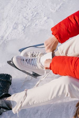 Woman sitting on snow and changing boots