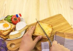Womans hand cutting french sandwich