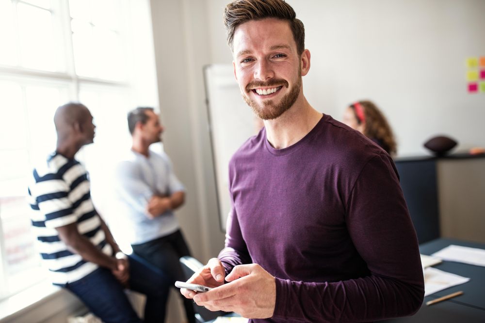 Smiling man with smart phone in hand