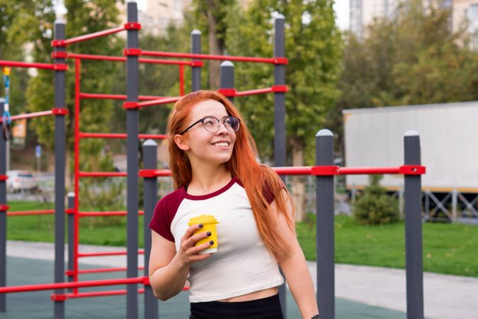 Woman smiling and holding yellow cup while taking break