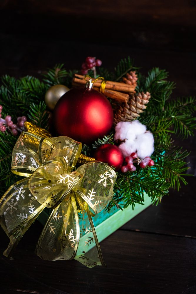 Rustic dark wooden background with red baubles, fir tree and cotton heads