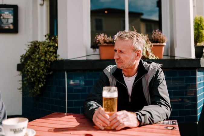 Man with pint of beer at outdoor pub