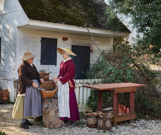 Two women with basket in historic 18th Century dress, Colonial Williamsburg, Virginia