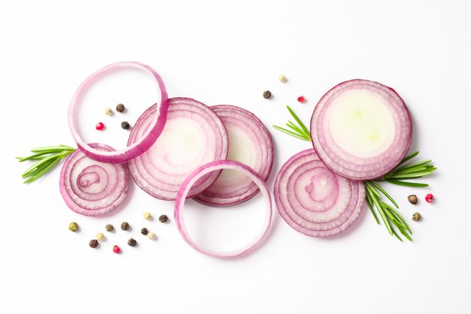 Flat lay composition with red onion rings and spices on blank background
